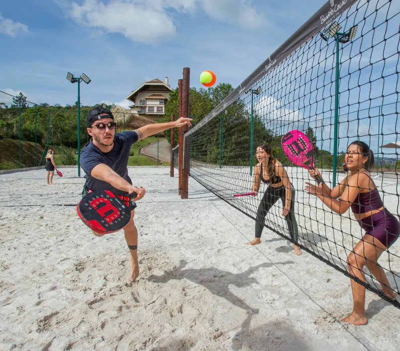 Um grupo de pessoas está jogando vôlei na praia.